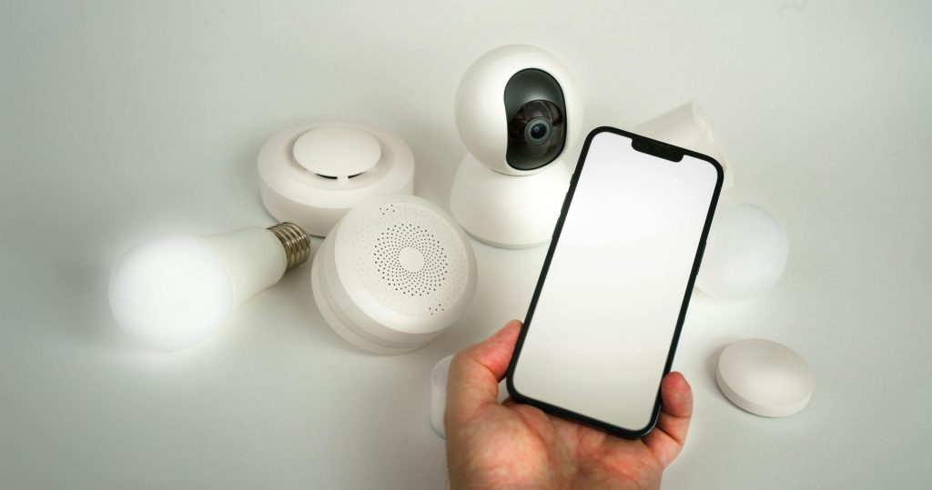 Présentation de divers appareils domestiques intelligents contrôlés via un smartphone, mettant en avant l'automatisation et la sécurité.